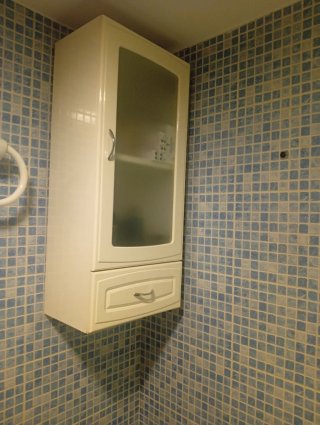 Mueble de baño blanco con puerta de cristal