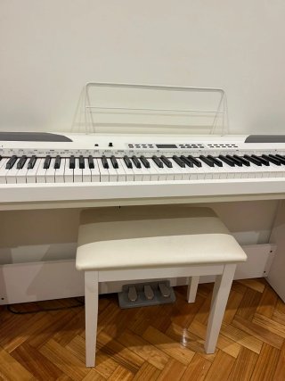 Piano blanco con silla y pedales