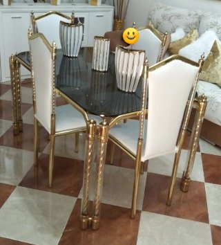 Mesa y sillas doradas y blancas