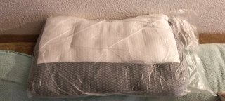 Almohada cervical gris y blanca