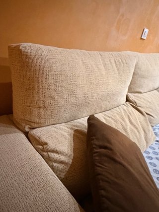 Sofá de tela beige con cojines marrones