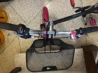 Bicicleta urbana rosa y negra con cesta