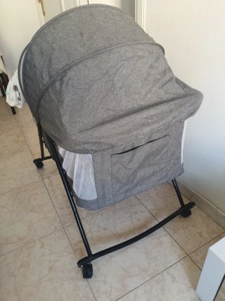 Cuna de viaje gris con mosquitera