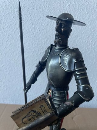 Figura Don Quijote armadura metal con libro.
