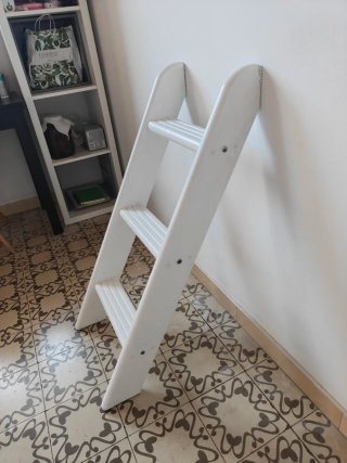 Escalera auxiliar blanca funciona como estantes