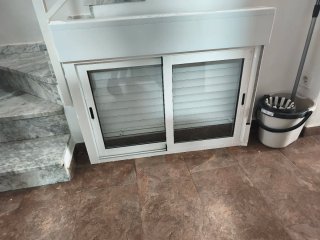 Ventana aluminio con persiana blanca