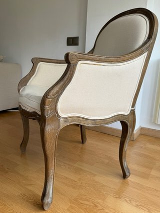 Butaca de madera y tela beige.