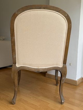 Butaca de madera y tela beige.