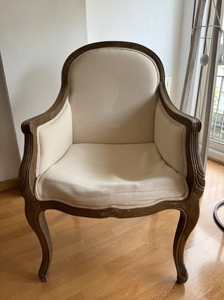 Butaca de madera y tela beige.