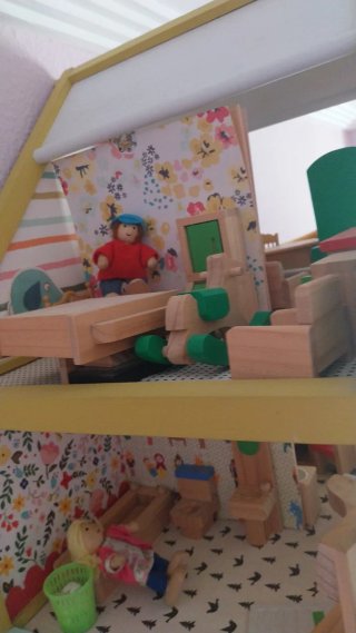 Casita de madera con  muñecos de madera.