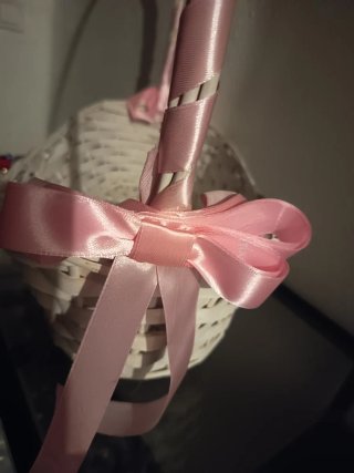 Cesta de mimbre blanca con lazos rosas