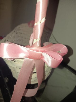 Cesta de mimbre blanca con lazos rosas