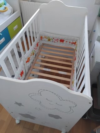 Cuna de madera blanca con diseño de nubes