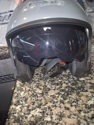 Casco de moto gris con dos viseras