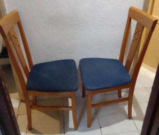 Dos sillas de madera con asiento azul