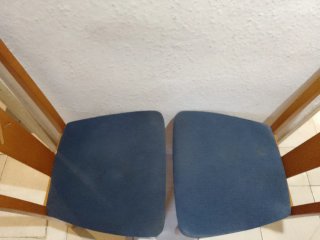 Dos sillas de madera con asiento azul