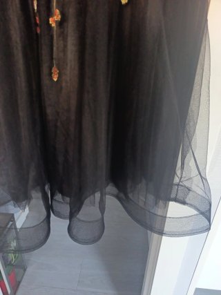 Elegante vestido negro bordado floral.