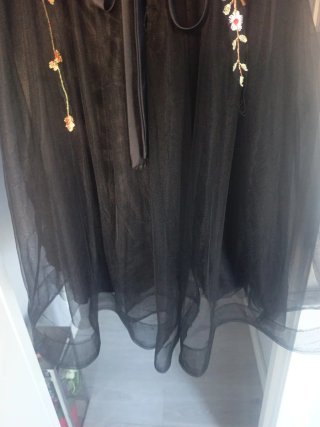 Elegante vestido negro bordado floral.