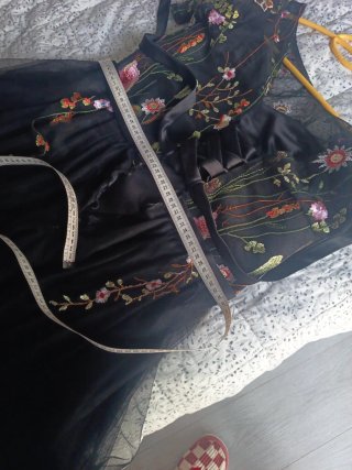 Elegante vestido negro bordado floral.