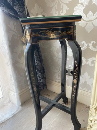 Mesa auxiliar negra y dorada con cristal