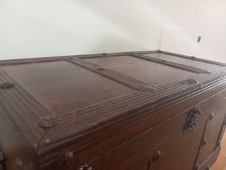 Baúl de madera antiguo con detalles metálicos.
