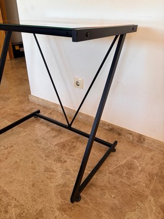 Due scrivanie con gambe in metallo e piano in vetro.