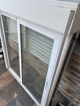 Ventana corredera blanca con persiana