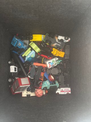 Caja con coches de juguete variados
