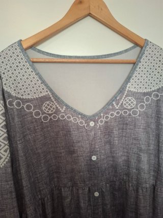 Blusa gris con bordados blancos