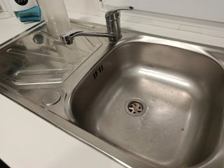 Mueble de cocina blanco, con pila y grifo