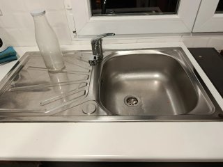 Mueble de cocina blanco, con pila y grifo