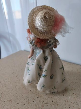 Muñeca de porcelana con sombrero floral
