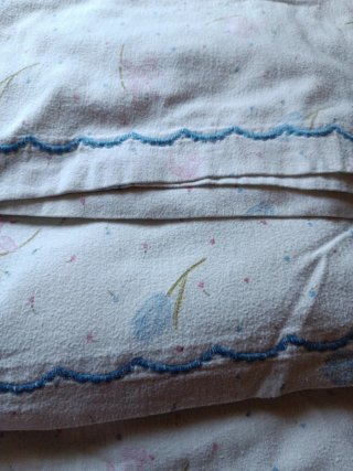Juego de sábanas blancas y rosas.