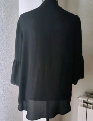 Blusa negra con volantes y cordones