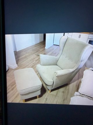 Sillón orejero beige con otomana