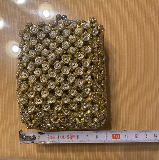 Bolso monedero dorado con pedrería.