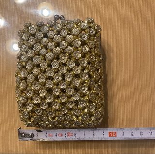 Bolso monedero dorado con pedrería.