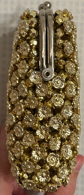 Bolso monedero dorado con pedrería.