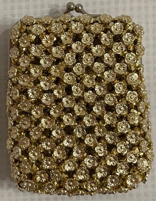 Bolso monedero dorado con pedrería.