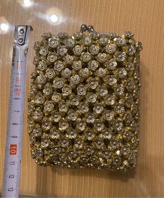 Bolso monedero dorado con pedrería.