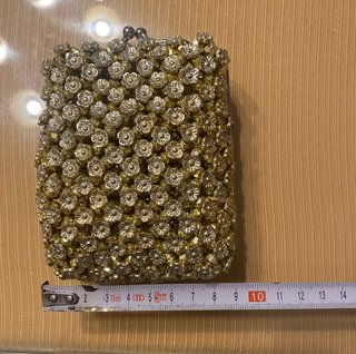 Bolso monedero dorado con pedrería.