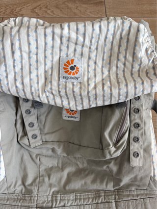 Mochila de porteo marca Ergobaby. Beige-grisácea.