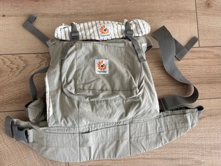 Mochila de porteo marca Ergobaby. Beige-grisácea.