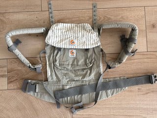 Mochila de porteo marca Ergobaby. Beige-grisácea.