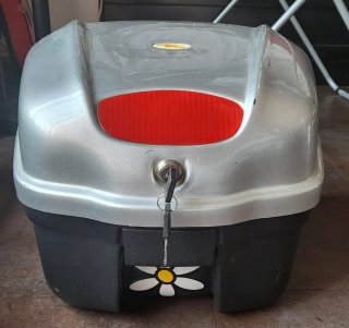 Cofre de moto plateado con tapa roja