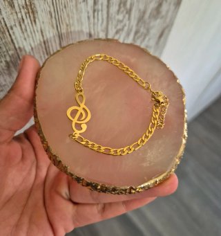 Pulsera de acero con clave de sol dorada