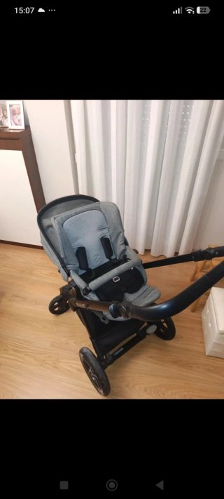 Carrito de bebé gris con protector de lluvia y sol