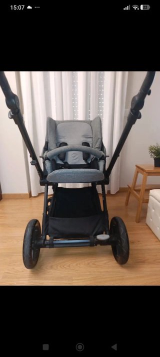 Carrito de bebé gris con protector de lluvia y sol