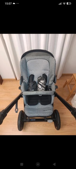 Carrito de bebé gris con protector de lluvia y sol