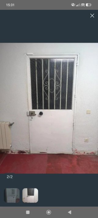 Puerta exterior blanca con reja